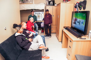 Students gather together in Rancourt Hall to take a break from studying and play a video game.